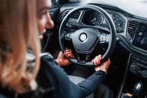 Rear view of beautiful blonde in elegant clothes that sitting inside of modern car photo