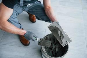 hombre con uniforme gris trabaja con placa en el interior de una gran oficina moderna durante el día foto