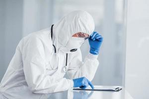 Male doctor scientist in lab coat, defensive eyewear and mask photo