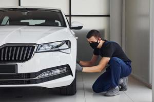 Man in blue uniform and black protective mask changing wheel photo