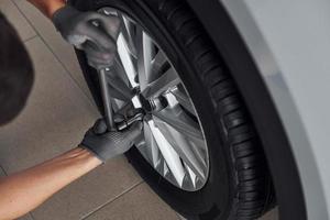 Close up view of man that changing tire of automobile. Conception of car service photo