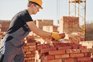 Construction worker in uniform and safety equipment have job on building photo