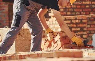 Construction worker in uniform and safety equipment have job on building photo