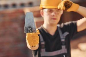 Portrait of construction worker in uniform and safety equipment that standing on building photo