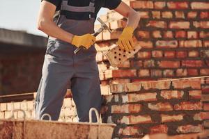 Busy with brick wall. Construction worker in uniform and safety equipment have job on building photo