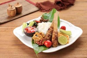 Nasi Campur Bali, Indonesian Balinese Rice with Sate Lilit, Ayam Sisit, Sambal Matah, and Peanut photo