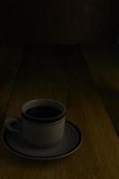 taza de café negro sobre un fondo de madera. área de espacio de copia foto