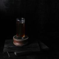 taza de té de vidrio sobre fondo negro foto