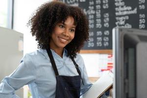 Successful Small Business Startup Small business owner SME Beauty Girl standing in front of a coffee shop with her arms crossed. Picture of an Asian female barista cafe owner. photo