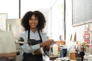 Successful Small Business Startup Small business owner SME Beauty Girl standing in front of a coffee shop with her arms crossed. Picture of an Asian female barista cafe owner. photo