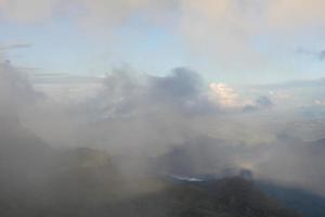 paisaje del valle de las montañas y el río desde la vista superior con cielo soleado y niebla foto