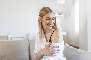 Young woman receiving getting vaccinated immunity with bandage on her upper arm, concept of innoculation, vaccination, side effects of vaccine photo