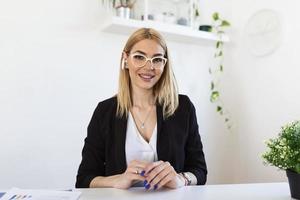 mujer joven feliz con auriculares hablando mirando una laptop haciendo notas, mujer de negocios hablando por videoconferencia, profesora tutora por cámara web, formación en línea, concepto de e-coaching foto