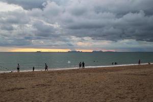 Travel to island Koh Lanta, Thailand. The view on the sand beach with walking people at the sunset. photo