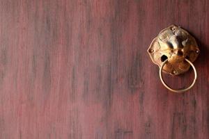 Fragment of the wooden painted door with ancient brass door knob. Chiangmai, Thailand. photo