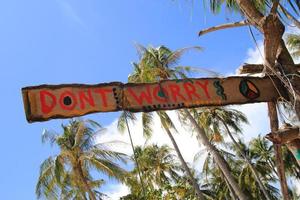 koh lanta, tailandia. una inscripción - no te preocupes - en la cabaña de madera abandonada. foto