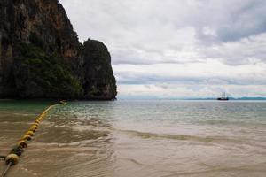 viajar a krabi, tailandia. la vista panorámica del mar y una roca de la playa de phra nang en el clima nublado. foto