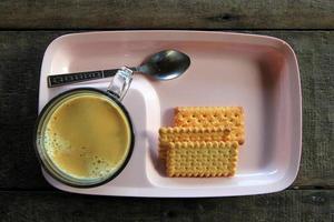 Travel to Doi Suthep, Chiangmai, Thailand. The cup of Thai coffee with cookies on the wooden background. photo