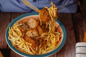 close-up of a plate of meatballs with spaghetti with cutlery