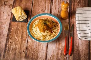 plate of meatballs with spaghetti with cutlery and bread
