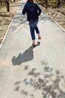 girl hopping in hopscotch on urban alley photo