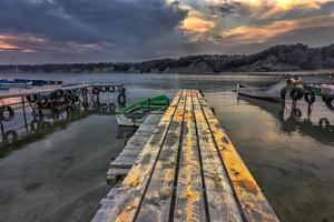 exciting landscape of wooden pier and boats at sunset photo