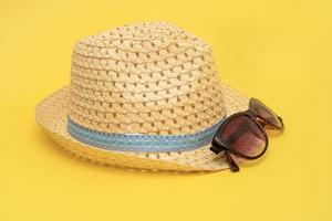 straw hat and sunglasses on a blue background photo