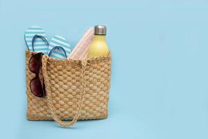 basket with beach accessories on a blue background with copy space photo