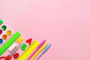 school accessories - rulers, pens, scissors, watercolor on a pink background with copy space, concept back to school, school background photo