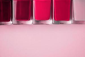 esmaltes de uñas sobre fondo rosa. color del año 2023 - magenta viva foto