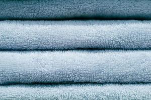 Stack of bath towels. Home textiles for spa treatments. Soft fluffy fabric. photo