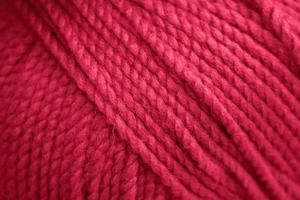 Texture of pink fluffy woolen threads for knitting. Color of the year 2023 - Viva Magenta photo