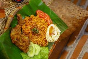 spicy noodle food with additional omelet and fried chicken photo