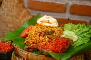 spicy noodle food with additional omelet and fried chicken photo