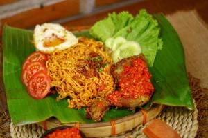 spicy noodle food with additional omelet and fried chicken photo