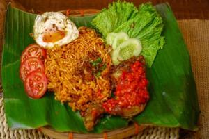 spicy noodle food with additional omelet and fried chicken photo