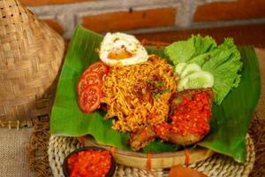 spicy noodle food with additional omelet and fried chicken photo