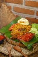 spicy noodle food with additional omelet and fried chicken photo