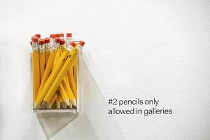 Box of yellow number two pencils on a wall at a gallery photo