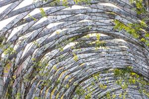 Arched wooden gazebo with lights in the middle of a park photo