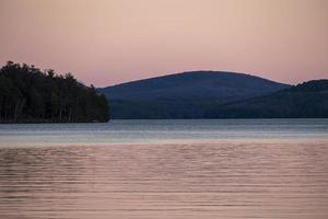 Pink rose colored sunset over a lake in the fall photo