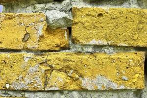 Detailed view at a colorful old and weathered brick wall texture as a panoramic background. photo