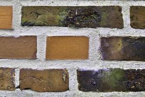 Detailed view at a colorful old and weathered brick wall texture as a panoramic background. photo