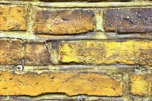 Detailed view at a colorful old and weathered brick wall texture as a panoramic background. photo