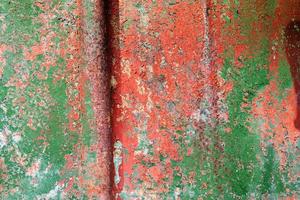 Detailed and colorful close up at cracked and peeling paint on concrete wall textures in high resolution photo