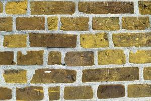Detailed view at a colorful old and weathered brick wall texture as a panoramic background. photo