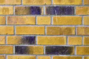 Detailed view at a colorful old and weathered brick wall texture as a panoramic background. photo