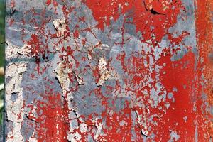 Detailed and colorful close up at cracked and peeling paint on concrete wall textures in high resolution photo