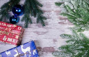 Flat lay composition with serpentine streamers and Christmas decor on wooden background. Space for text Balls, branches, hat, photo