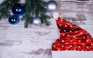 Flat lay composition with serpentine streamers and Christmas decor on wooden background. Space for text Balls, branches, hat, photo